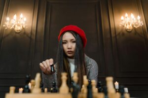 A woman playing chess to signify playing the long content game with a strategy